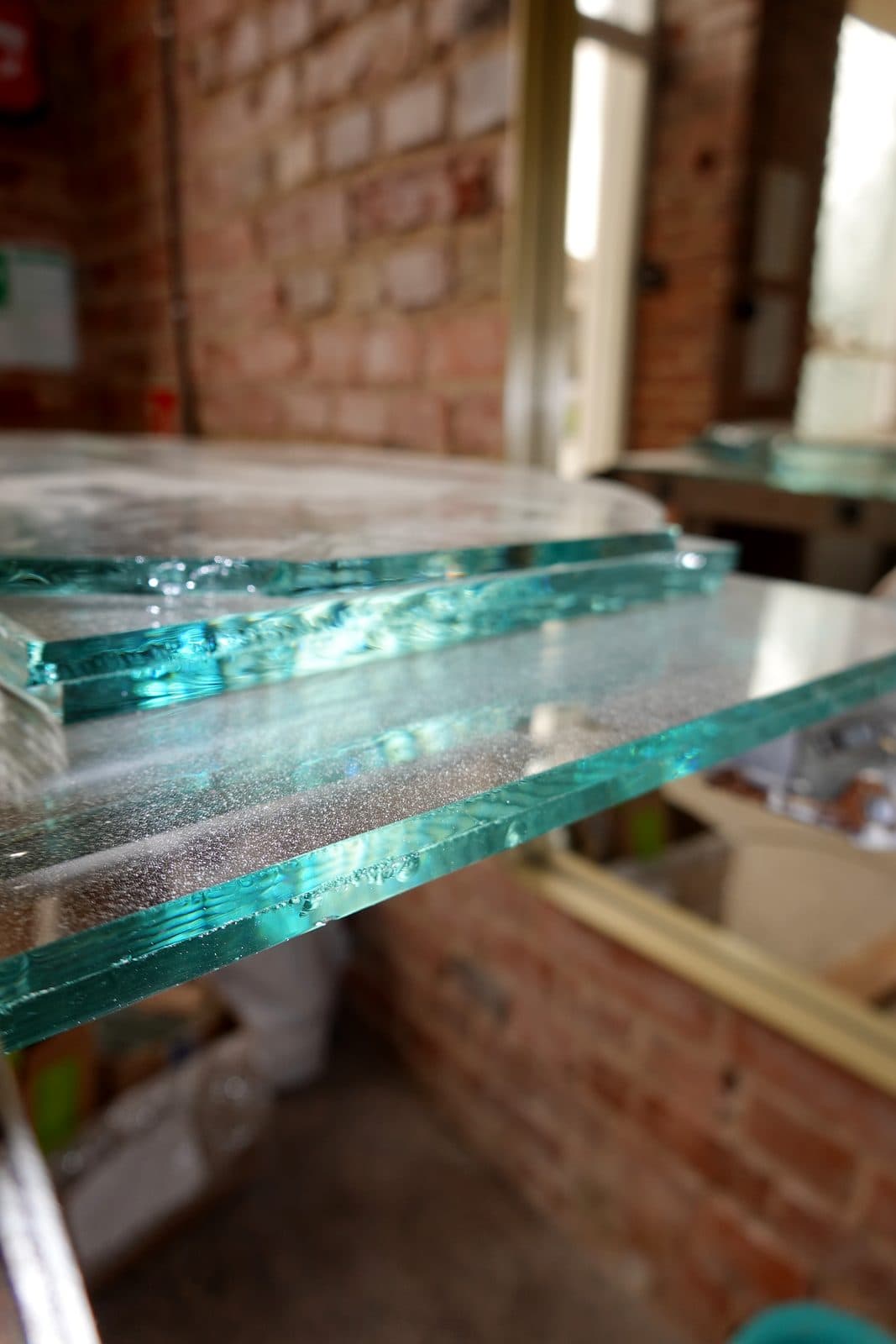 Glass sheets on a rack by a brick wall